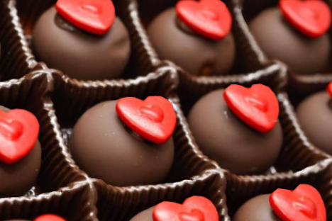 Chocolates with red heart decorations in a tray.