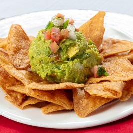 Smash avocado with pepper, onion, cilantro and lemon juice serving with fried plantains chips.